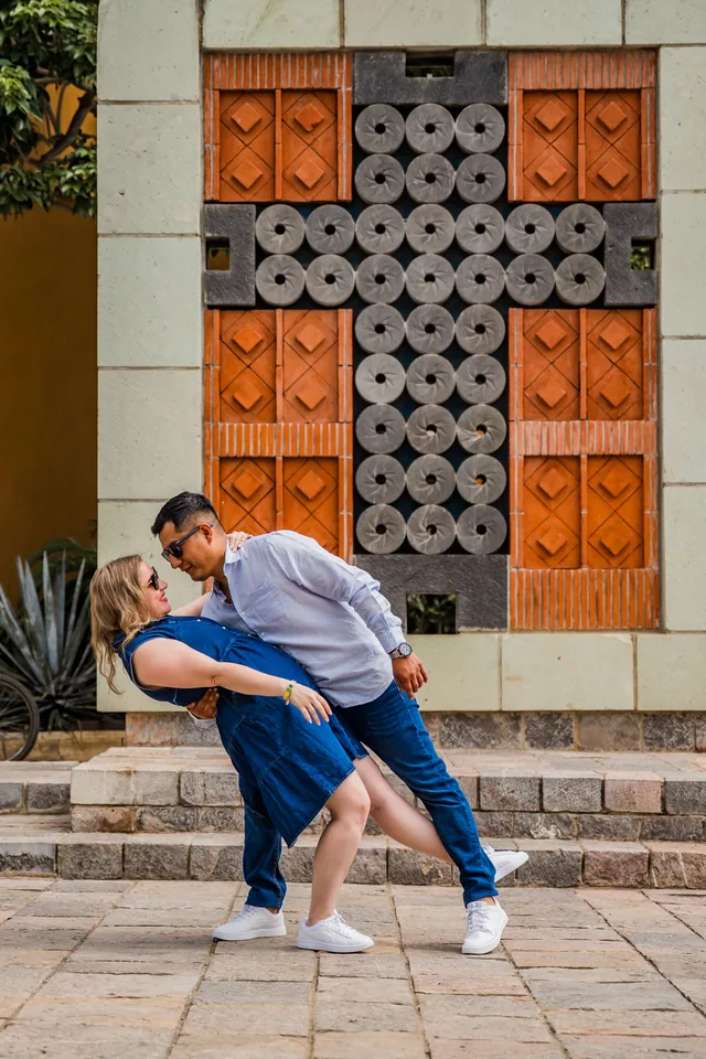Pablo inclinando a Maria Esthela frente a un portón de madera